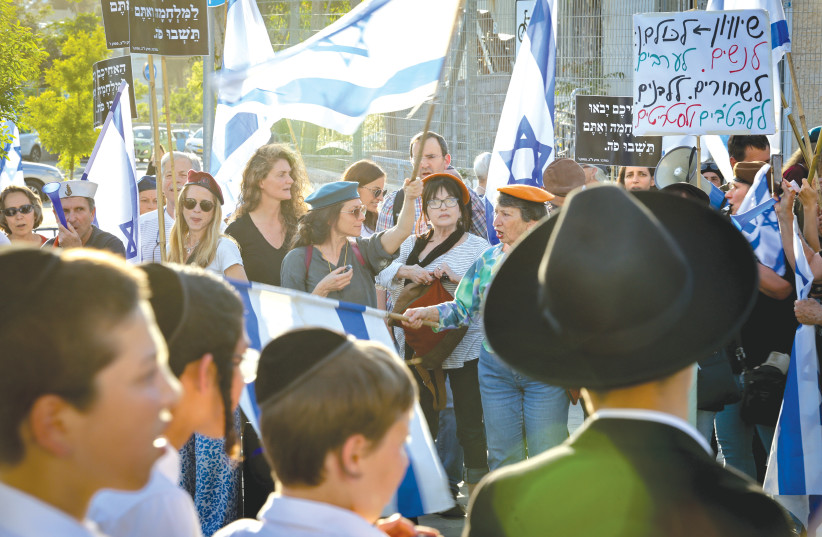  PROTESTERS STAND across from haredi boys in front of Kol Torah Yeshiva in Jerusalem, earlier this month.  (photo credit: NOAM REVKIN FENTON/FLASH90)