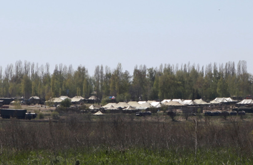  Russian military vehicles and army tents are seen in a field outside the village of Severny in Belgorod region near the Russian-Ukrainian border, April 25, 2014 (credit: REUTERS/SERGEI KHAKHALEV)