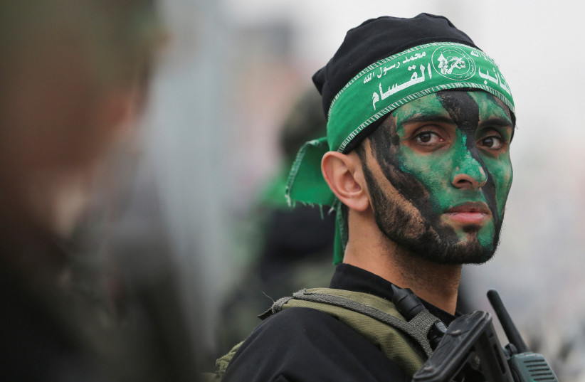  A member of Hamas takes part in a rally during the 35th anniversary of Hamas founding, in Khan Younis in the southern Gaza Strip December 14, 2022.  (credit: IBRAHEEM ABU MUSTAFA/REUTERS)