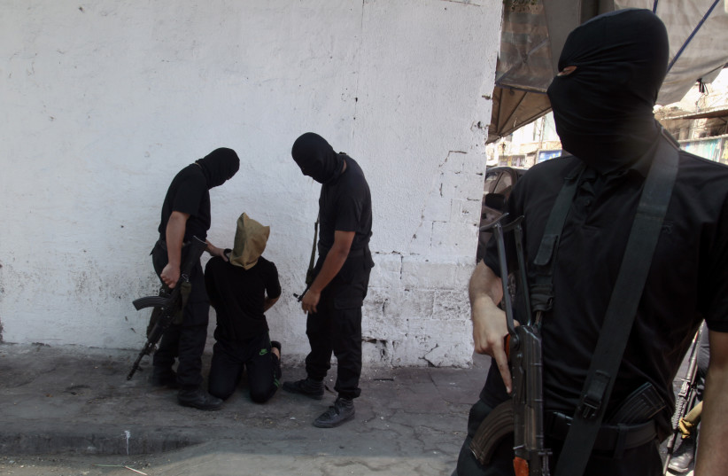  Hamas militants grab a Palestinian suspected of collaborating with Israel, before being executed in Gaza City August 22, 2014 (photo credit: REUTERS/STRINGER)