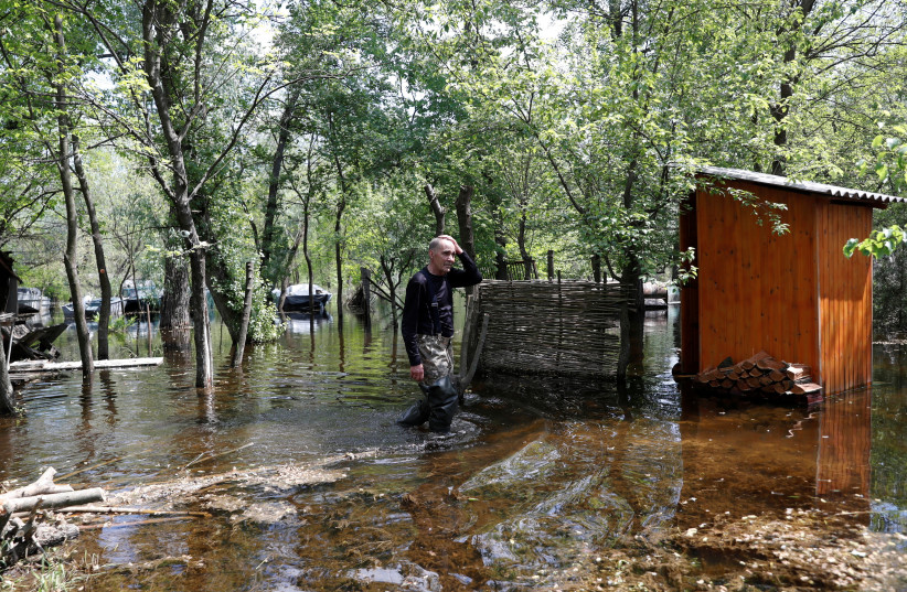 Ihor Medunov walks on a flooded island which locals and officials say is caused by Russia's chaotic control of the Kakhovka dam downstream, amid Russia's attack on Ukraine, near Zaporizhzhia, Ukraine, May 20, 2023. (credit: Bernadett Szabo/Reuters)