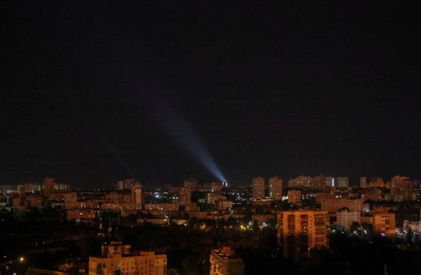 A view shows a flash from the explosion as Ukrainian servicemen use a searchlight to search for drones in the sky over the city during a Russian drone strike, amid Russia's attack on Ukraine, in Kyiv, Ukraine May 28, 2023.