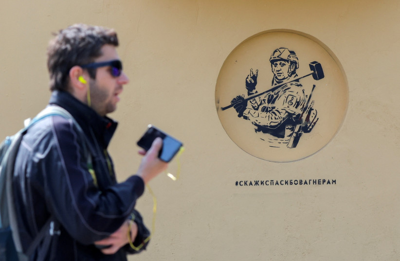  A man walks past a graffiti, which depicts Wagner mercenary group's founder Yevgeny Prigozhin and was created by Russian artist Alexey Chizhov to support the private military company, in Saint Petersburg, Russia, May 26, 2023. A sign reads: ''Say thanks to Wagner (soldiers).'' (credit: ANTON VAGANOV/ REUTERS)