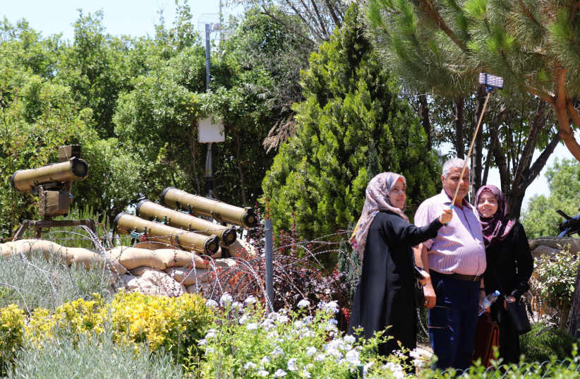 People take selfies during a visit at the Hezbollah-run ''Tourist Landmark of the Resistance'' war museum in Mlita (aka Mleeta), where weapons left behind in Lebanon by Israeli forces are displayed, on July 12, 2016 in southern Lebanon.