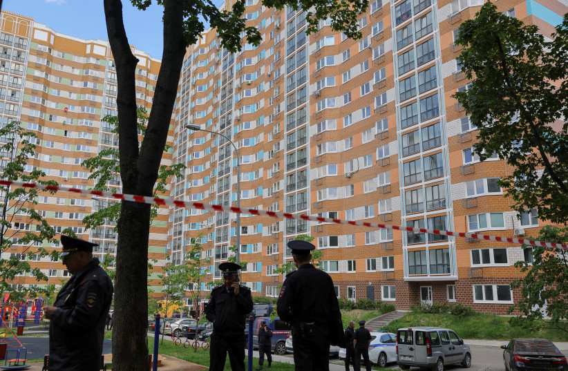  Russian law enforcement officers stand guard near a damaged multi-storey apartment block following a reported drone attack in Moscow, Russia, May 30, 2023. (credit: REUTERS/EVGENIA NOVOZHENINA)