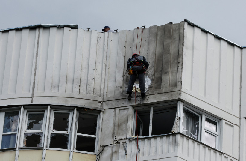  Workers repair damage on the roof of a multi-storey apartment block following a reported drone attack in Moscow, Russia, May 30, 2023 (credit: REUTERS/MAXIM SHEMETOV)