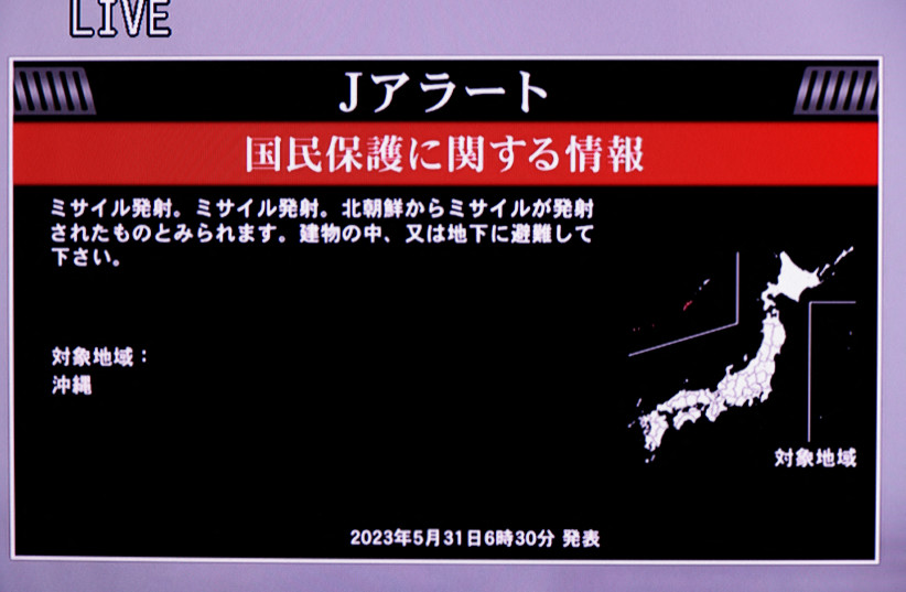   A TV screen displays a warning message called ''J-alert'' after the Japanese government issued an emergency warning for residents of the southern prefecture of Okinawa, saying a missile had been launched from North Korea, in Tokyo, Japan May 31, 2023 (credit: REUTERS/Issei Kato/File Photo)