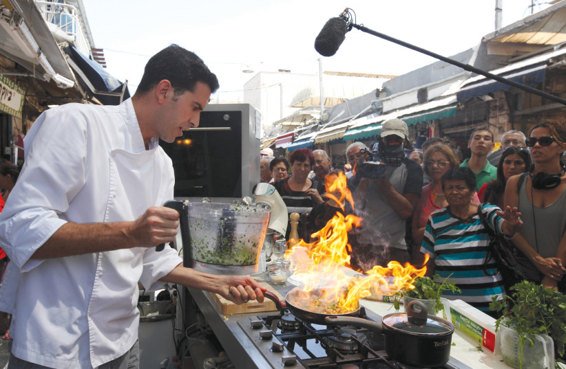  A chef cooks in Jerusalem’s Mahaneh Yehuda market. (credit: MARC ISRAEL SELLEM)
