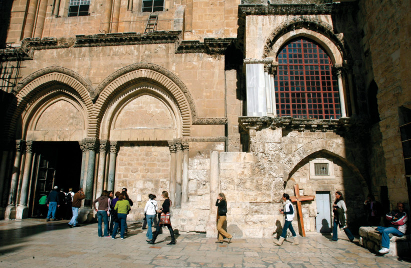  Pilgrims walk outside the Church of the Holy Sepulcher in Jerusalem’s Old City. Jerusalem syndrome can cause visitors to be so overcome by the spiritual magnitude of the city that they believe they are prophets or characters from the Bible.  (credit: AMMAR AWAD/REUTERS)