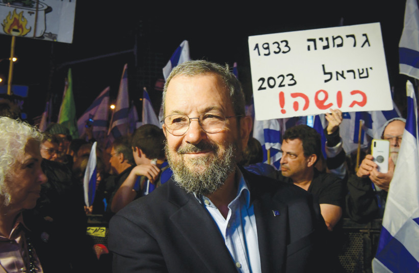  FORMER PRIME minister Ehud Barak attends a protest against the government’s planned judicial overhaul, in Tel Aviv, earlier this year. The sign behind him reads: ‘Germany 1933, Israel 2023, disgrace!’  (credit: AVSHALOM SASSONI/FLASH90)