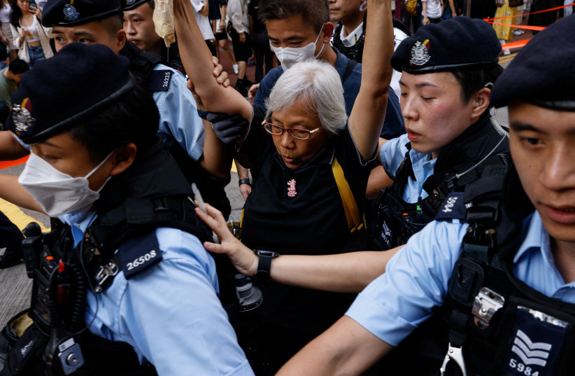  Police detain a woman in downtown on the 34th anniversary of the 1989 Beijing's Tiananmen Square crackdown, near where the candlelight vigil is usually held, in Hong Kong, China June 4, 2023. (credit: TYRONE SIU/ REUTERS)