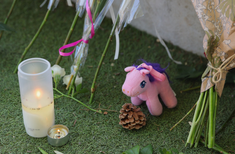  A view of a toy, flowers and candles left at the Le Paquier park after several children and adults were injured in a knife attack, near the lake in Annecy, in the French Alps, France, June 9, 2023 (credit: REUTERS/DENIS BALIBOUSE)