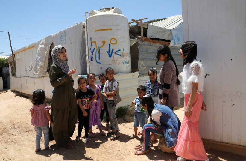  Asmaa Rasheed, a Syrian refugee storyteller living in Zaatari refugee camp, welcomes children before her storytelling session at the camp, in the Jordanian city of Mafraq, near the border with Syria, Jordan June 17, 2021.  (credit: REUTERS/ALAA AL SUKHNI)