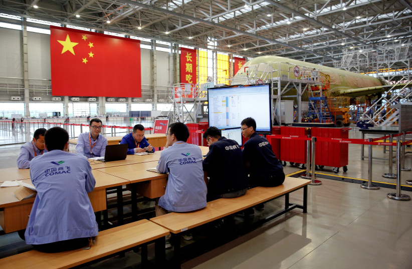   Employees work on a China's home-grown C919 passenger jet at Manufacturing and Final Assembly Center of state-owned Commercial Aircraft Corporation of China (COMAC) during a media tour in Shanghai, China May 4, 2017.  (credit: REUTERS/ALY SONG/FILE PHOTO)