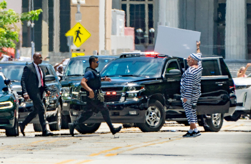 A man gestures as the motorcade of former US president Donald Trump ahead of Trump's appearance in federal court in Miami, Florida, to be arraigned on 37 criminal charges, in Manhattan in New York City, New York, US, June 13, 2023 (credit: GREG LOVETT/TTHE PALM BEACH POST/USA TODAY NETWORK VIA REUTERS)