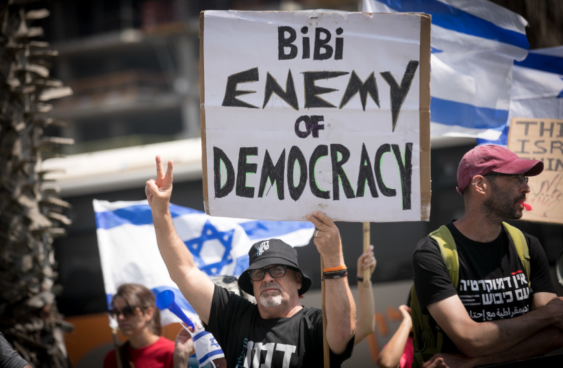  Israeli demonstartors protest outside the AJC Global Forum where Diaspora Minister Amichai Chikli spoke, in Tel Aviv, on June 14, 2023 (credit: MIRIAM ALSTER/FLASH90)
