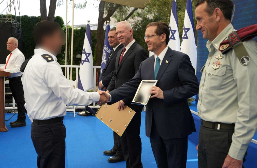  President Isaac Herzog, with Defense Minister Yoav Gallant to his right and IDF Chief of Staff Lt. Gen. Herzi Halevi to his left, hands an award to one of the winners.  (credit: MINISTRY OF DEFENSE SPOKESPERSON'S OFFICE)