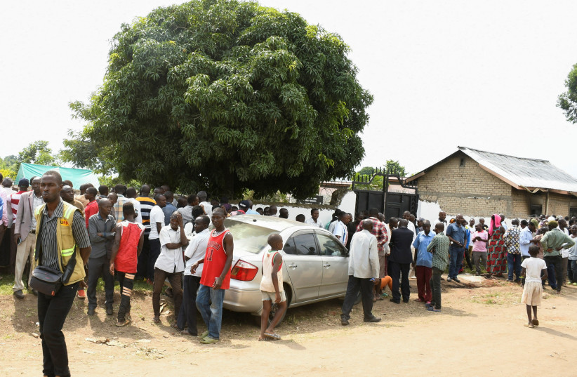 Locals gather at the cordoned scene outside the Mpondwe Lhubirira Secondary School, after militants linked to rebel group Allied Democratic Forces (ADF) killed and abducted multiple people, in Mpondwe, western Uganda, June 17, 2023. (credit: REUTERS)