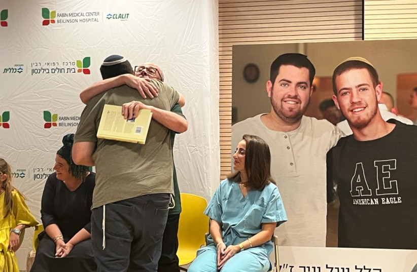  Ron Carmeli (with glasses), who was one recipient, hugs Shalom Yaniv (credit: TAMAR COHEN)
