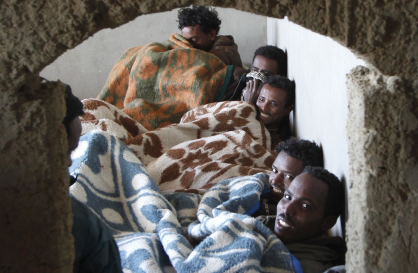  Migrants from Eritrea rest in a building, used to house people waiting to be smuggled into Israel, near the Egyptian-Israeli border in Sinai December 25, 2010. Sinai's border with Israel is a main trafficking route for thousands of African migrants seeking asylum in Israel.  (credit: REUTERS/ASMAA WAGUIH)