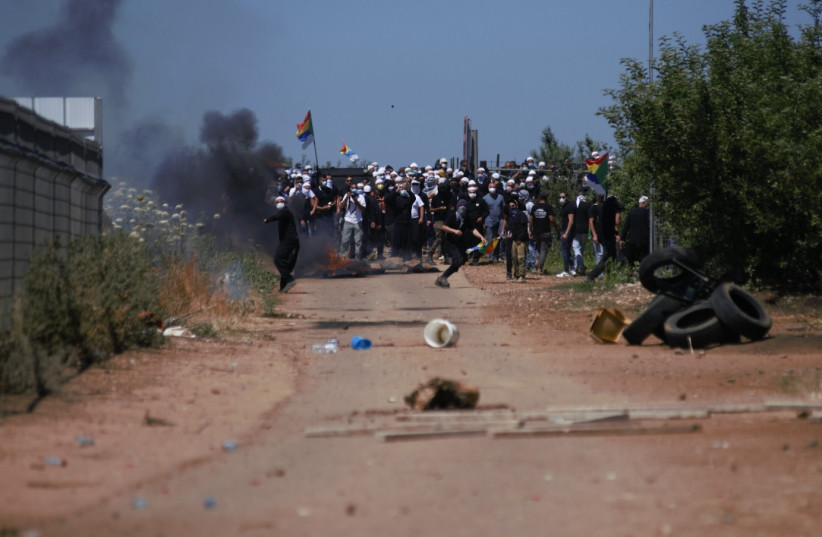 Druze protest while police guard during a protest against the construction of a new wind farm near the Druze village of Majdal Shams, in the Golan Heights, June 21, 2023. (credit: ISRAEL POLICE SPOKESPERSON'S UNIT)