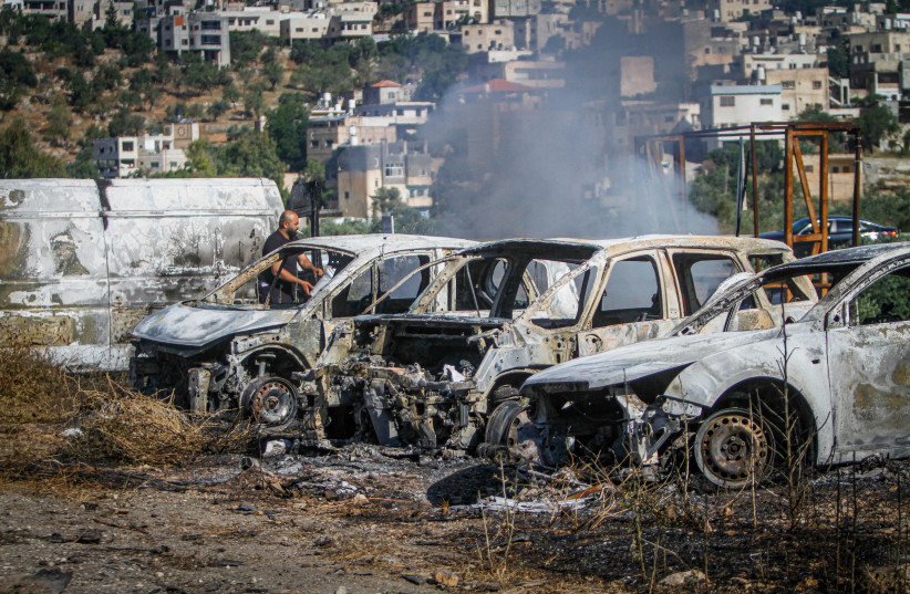 Palestinians check burned vehicles after Israeli settlers attack near Ramallah in the West Bank, June 21,2023 (credit: NASSER ISHTAYEH/FLASH90)
