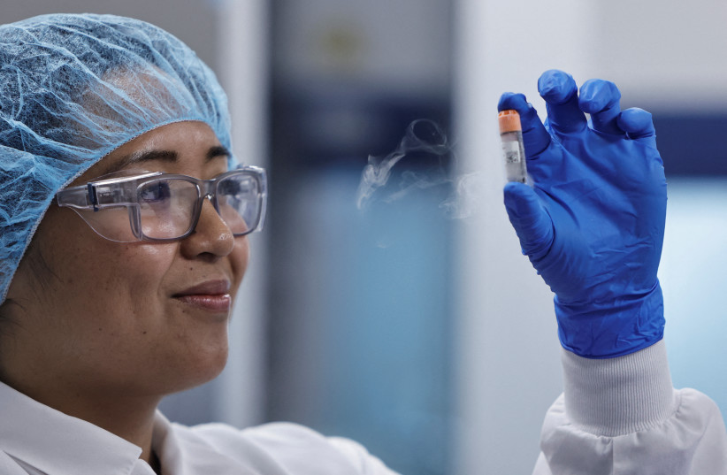  A lab employee holds a vial of frozen chicken cells in the seed lab at the UPSIDE Foods plant, where lab-grown meat is cultivated, in Emeryville, California, US January 11, 2023.  (credit: REUTERS/Peter DaSilva)