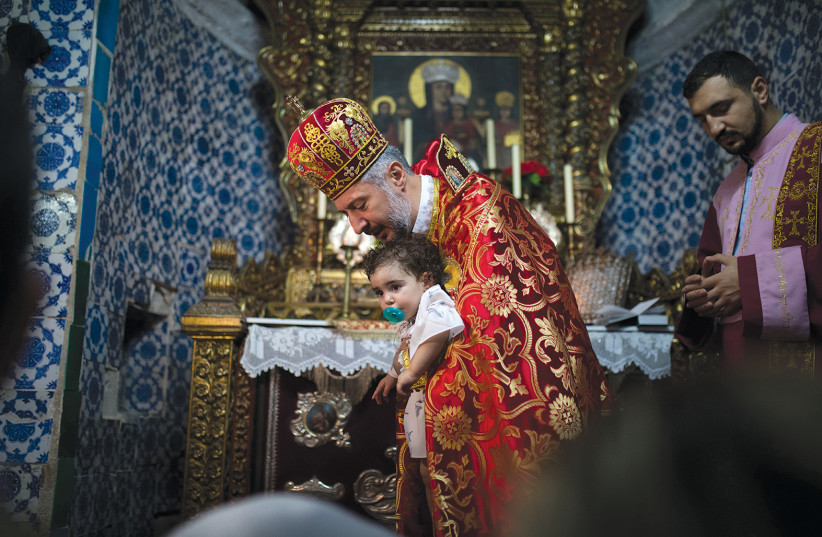  PERFORMING A baptism ceremony in St. James Cathedral in the Old City of Jerusalem's Armenian Quarter. (credit: FLASH90)