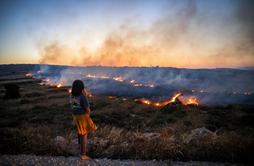  A field fire during clashes between Palestinians and Jewish settlers near the Palestinian village of Qusra, in the West Bank, June 22, 2023 (credit: FLASH90)