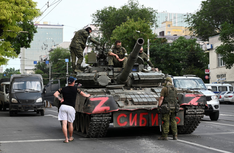 A man speaks with fighters of Wagner private mercenary group deployed in a street near the headquarters of the Southern Military District in the city of Rostov-on-Don, Russia, June 24, 2023 (credit: REUTERS/STRINGER)