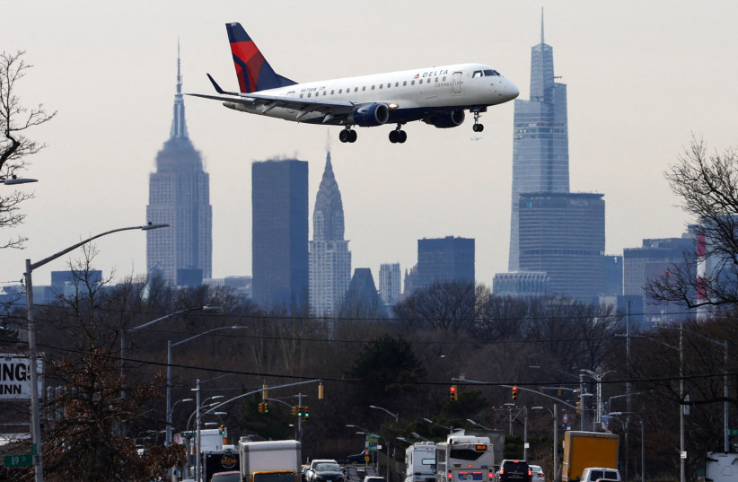  A Delta Airlines jet comes in for a landing in front of the Empire State Building and Manhattan skyline at Laguardia Airport, in New York City, New York, U.S., January 11, 2023. (credit: REUTERS/MIKE SEGAR/FILE PHOTO)