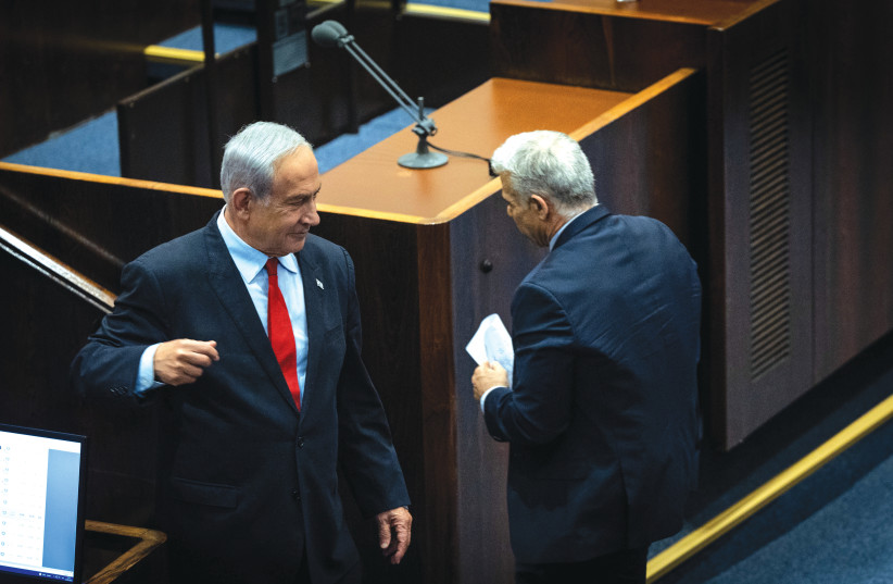  PRIME MINISTER Benjamin Netanyahu and opposition leader Yair Lapid cross paths in the Knesset plenum during the budget debate last month. (credit: YONATAN SINDEL/FLASH90)
