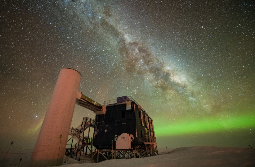  The IceCube Lab is seen under a starry, night sky, with the Milky Way appearing over low auroras in the background. (credit: Yuya Makino, IceCube/NSF)