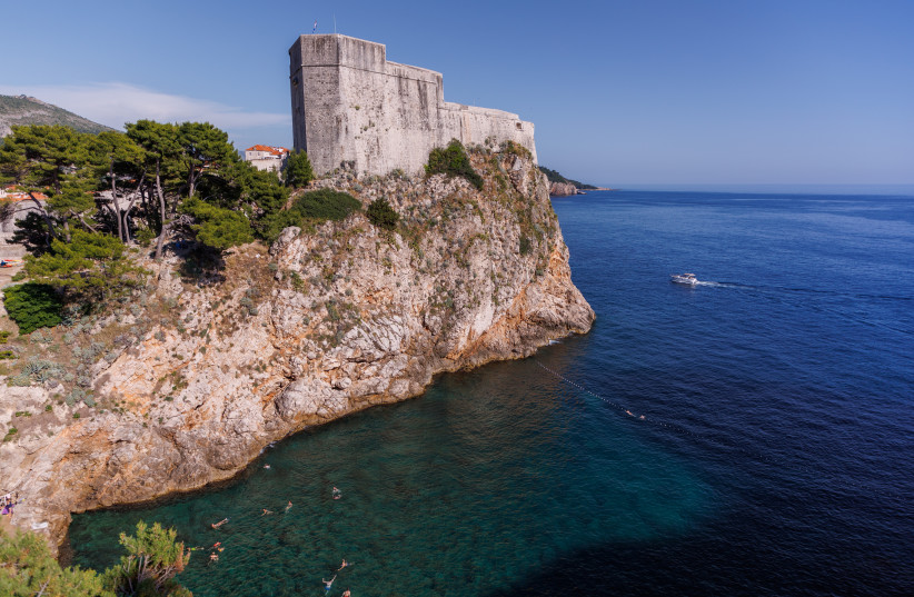 People swim near the Walls of Dubrovnik, Croatia June 7, 2022. Picture taken June 7, 2022. (credit: ANTONIO BRONIC/REUTERS)