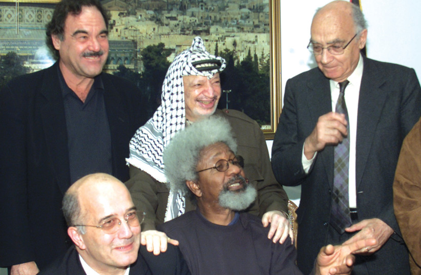  OLIVER STONE (top left) with a delegation of international figures, meet with then-Palestinian Authority president Yasser Arafat in Ramallah in 2002 (credit: LASZLO BALOGH/REUTERS)