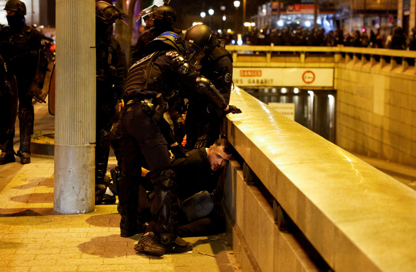  Police hold down a young person during the fifth night of protests following the death of Nahel, a 17-year-old teenager killed by a French police officer in Nanterre during a traffic stop, in the Champs Elysees area, in Paris, France, July 2, 2023. (credit: REUTERS)