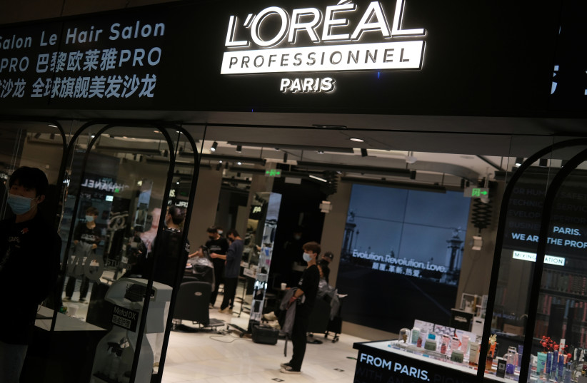 Staff members work at a hair salon of L’Oreal in Beijing, China November 18, 2021. (credit: TINGSHU WANG/REUTERS)