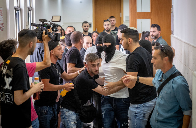  Family members and the border police officer who accused of shooting and killing of Iyad al-Hallak, a 32-year-old special needs student in the Old City of Jerusalem, seen with their faces covered at the district court in Jerusalem, July 6, 2023 (credit: YONATAN SINDEL/FLASH90)