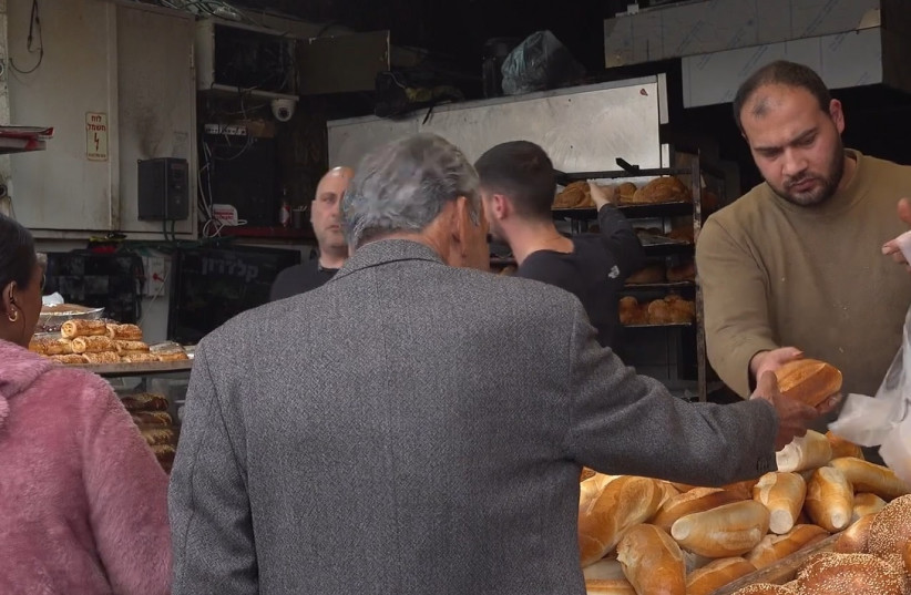 A vendor sells bread in Jerusalem's Machane Yehuda Market, July 3, 2023. (credit: DARIO SANCHEZ/THE MEDIA LINE)