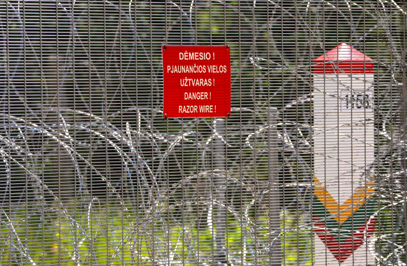 Sign ''Razor Wire'' and Lithuanian border pole is seen on Belarus border in Kaniukai, Lithuania July 7, 2023. (credit: JANIS LAZIANS/REUTERS)