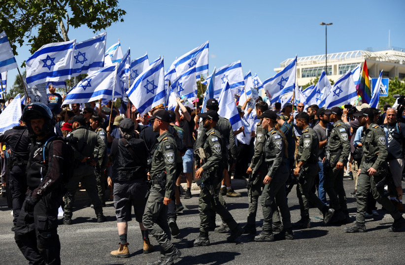  Members of the security forces stand guard as people demonstrate on 'Day of Disruption' in protest against Israeli Prime Minister Benjamin Netanyahu and his nationalist coalition government's judicial overhaul, outside the Supreme Court in Jerusalem, July 11, 2023. (credit: RONEN ZVULUN/REUTERS)
