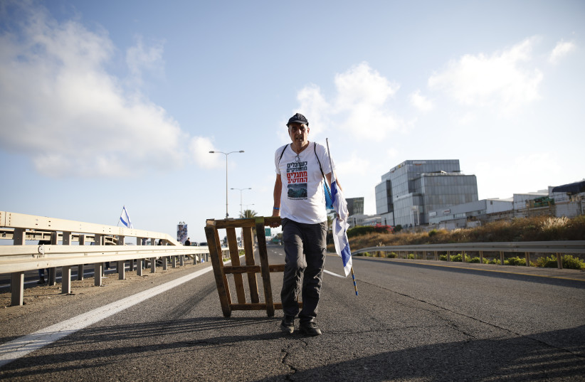  Anti-judicial overhaul demonstrators block a main road at the entrance to Haifa, during a protest against the judicial overhaul on July 11, 2023.  (credit: SHIR TOREM/FLASH90)