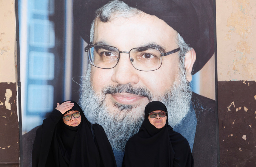  Women sit near a picture of Lebanon's Hezbollah leader Sayyed Hassan Nasrallah, during an event marking the commemoration of Israel's withdrawal from southern Lebanon in 2000, at the former Khiam prison, in Khiam village, southern Lebanon, May 25, 2023 (credit: AZIZ TAHER/REUTERS)