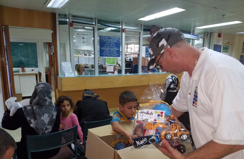  DISTRIBUTING TOYS to Syrian children in an Israeli hospital. (credit: GDC Inc.)