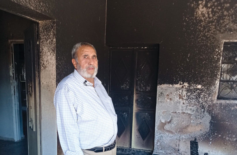Mohammed Hejjaz stands in his burnt home in Turmus Ayya.