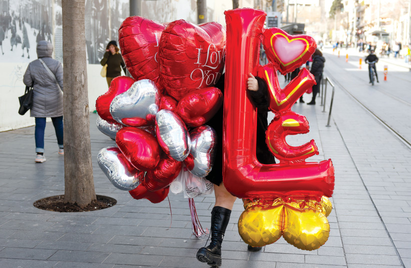  A woman carries red balloons on Tu Be’av. (credit: MARC ISRAEL SELLEM)