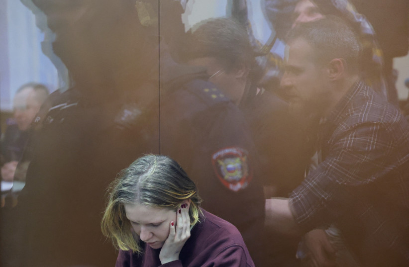 Darya Trepova, who is suspected of the killing of Russian military blogger Maxim Fomin widely known by the name of Vladlen Tatarsky, sits behind in an enclosure for defendants as journalists and law enforcement officers are reflected in a glass wall during a hearing in Moscow, Russia, April 4, 2023