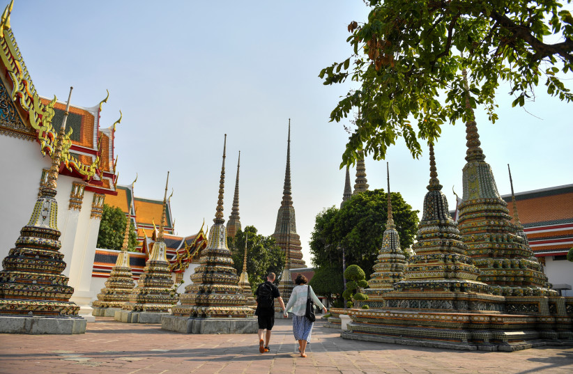  A couple walks at an empty Wat Po temple in Bangkok, Thailand, March 3, 2020.  (credit: REUTERS/Chalinee Thirasupa)