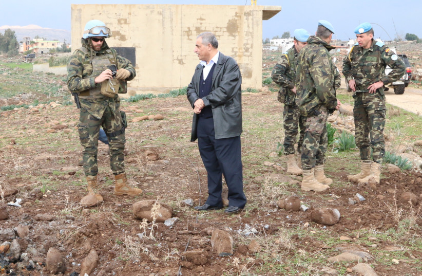 Amal Movement MP Qassem Hashem stands with members of UN peacekeepers of UNIFIL as they inspect an area that was hit by shells fired from Israel, around the town of Al Wazzani, near the Lebanese-Israeli border, in southern Lebanon. (credit: REUTERS/KARAMALLAH DAHER)