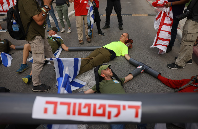 Israelis block the entrance to the Defense Ministry in Tel Aviv as they protest the governments planned judicial reform. July 18, 2023. (credit: Chaim Goldberg/Flash90)